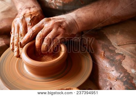Close-up Hands Of A Male Potter In Plaid Shirt And Dirty Apron Who Molds A Vase From Clay, Selective