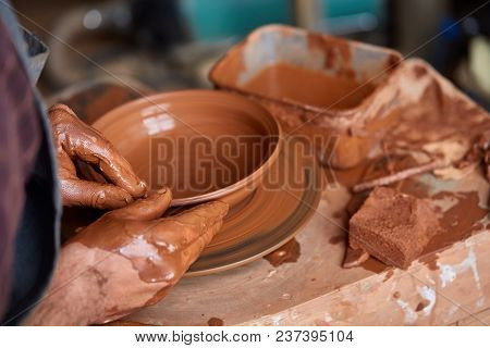 Close-up Hands Of A Male Potter In Plaid Shirt And Dirty Apron Who Molds A Vase From Clay, Selective