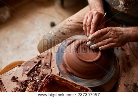 Close-up Hands Of A Male Potter In Plaid Shirt And Dirty Apron Who Molds A Vase From Clay, Selective