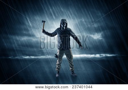Terrorist in a stormy space with gas mask on his hand and weapons on his arm