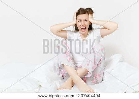 Stressed Crazy Mad Young Screaming Woman Sitting In Bed With White Sheet, Pillow, Blanket. Shocked F