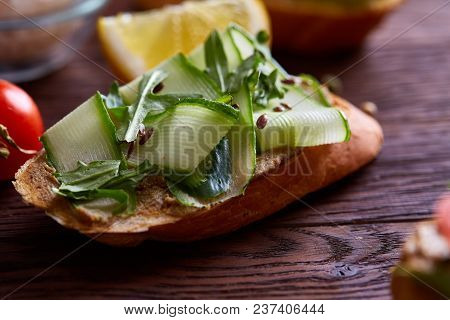 Breakfast Sandwich With Homemade Paste, Vegetables And Fresh Greenson Wooden Cutting Board Over Rust