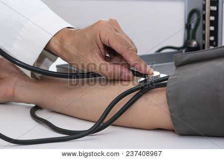 Doctor Measuring Blood Pressure In Medical Office