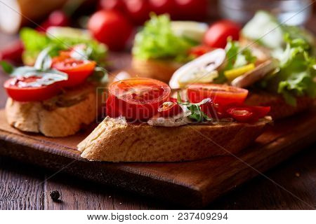 Breakfast Sandwich With Homemade Paste, Vegetables And Fresh Greenson Wooden Cutting Board Over Rust