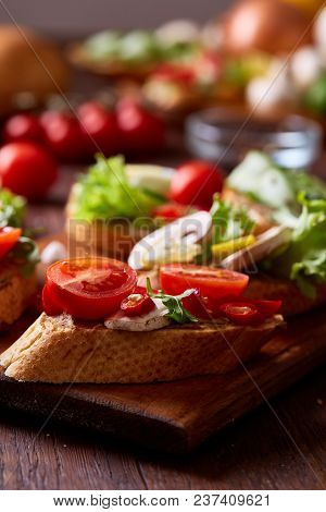Breakfast Sandwich With Homemade Paste, Vegetables And Fresh Greenson Wooden Cutting Board Over Rust