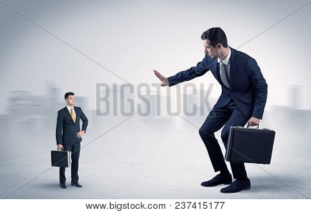 Giant businessman being afraid of small serious executor with suitcase
