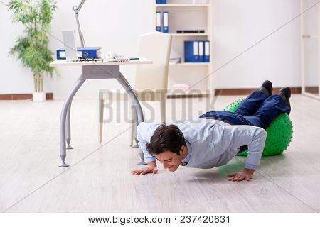 Employee exercising with swiss ball during lunch break