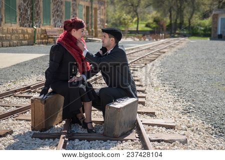 Young Couple Woman Crying And In Deep Thoughts Siting On The Trainlines Waiting For The Next Train R