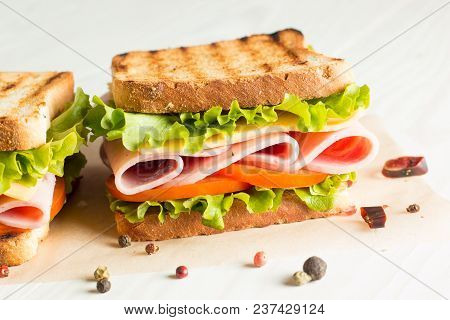 Close-up Photo Of A Club Sandwich. Sandwich With Meet, Prosciutto, Salami, Salad, Vegetables, Lettuc