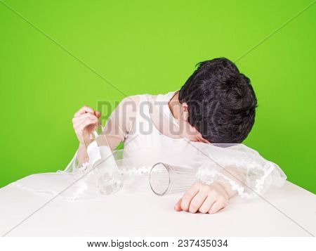 Portrait Of A Sad Bride Crying And Drinking Spirits. The Concept Of A Deceived And Abandoned Bride