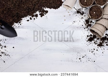 Gardening Tools, Seedling Peat Pots, Seeds And Soil On A White Wooden Table. Image Shot From Above I