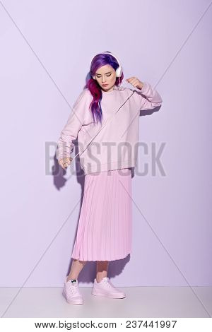 Dancing Young Woman With Purple Hair In Pink Clothes Listening Music With Wired Headphones