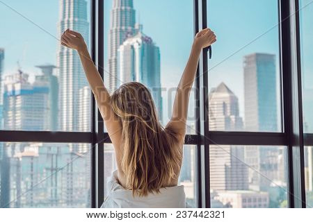Woman Wakes Up In The Morning In An Apartment In The Downtown Area With A View Of The Skyscrapers. L