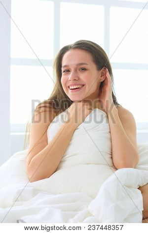 Young caucasian woman covering her head and ears with pillows