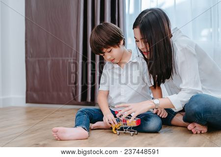 Mother Playing With Son Preschool Education With Toy And Cart In The Morning At Home For Kindergarte