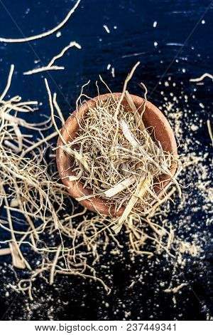 Dried Vetiver Grass Or Khus Or Chrysopogon Zizanioides Grass In A Clay Bowl On Wooden Surface.
