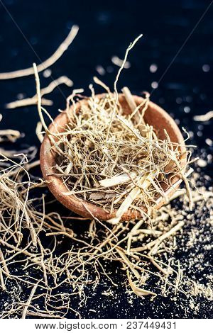 Dried Vetiver Grass Or Khus Or Chrysopogon Zizanioides Grass In A Clay Bowl On Wooden Surface.