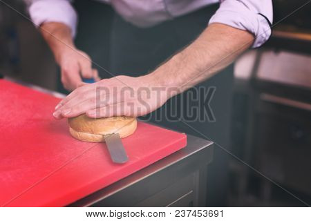 master chef hands cutting rolls for a burger in the rastaurant kitchen