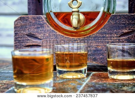 Alcohol,taste And Drink Concept-glasses With Whiskey,old Glass Barrel On Stone Table And Wooden Back