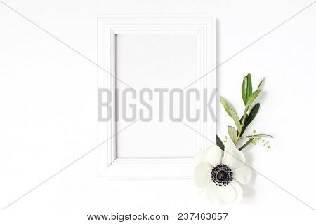 White Blank Wooden Picture Frame Mockup With Green Olive Branch And Anemone Flower Lying On The Whit