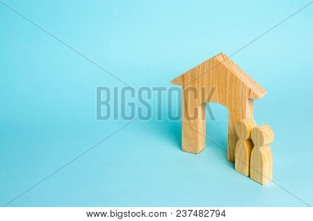 Two people stand near the house and evaluate its qualities before buying. The concept of buying and selling immobility. Parents are waiting at home. Housing for a couple. Rental of property