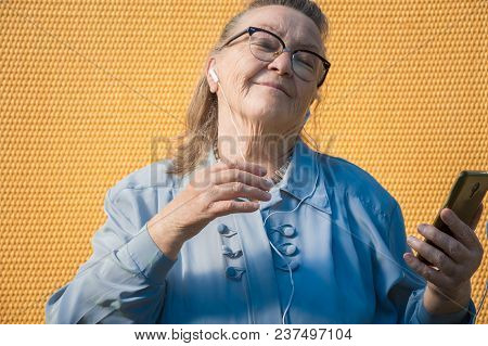 Portrait Of Old Lady, Grandmother Makes Selfie Outdoors At Sun Day. Modern Caucasian Granny Finger  