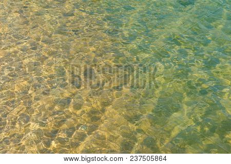 Nature Texture Of Clear Transparent Water Surface With Ripples And Sand. Nature Background