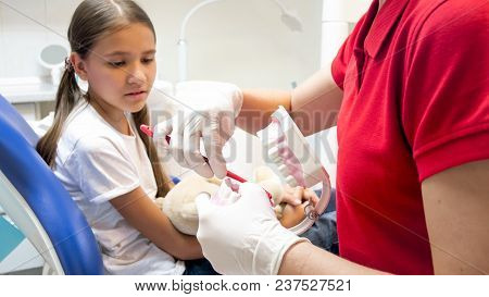 Closeup Of Pediatric Dentist Explaining How To Properly Clean Teeth To Her Patient