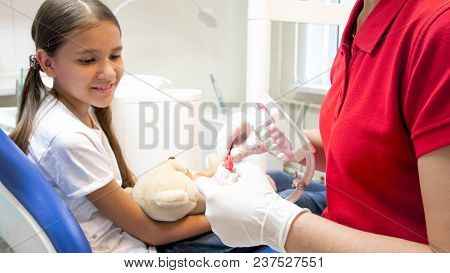 Closeup Of Pediatric Dentist Explaining How To Clean Teeth On Jaw Model