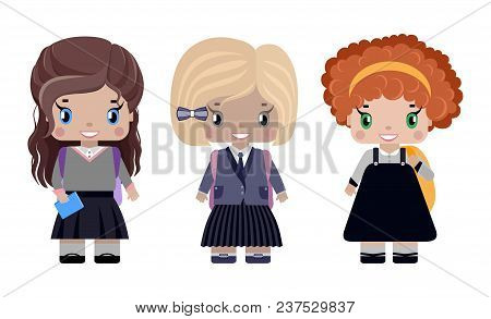 Three Little Girls In Different School Uniforms And With Backpacks Smiling (first Graders)