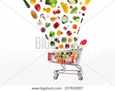 Grocery Cart With Vegetables And Fruits Falling In It Isolated On White. Healthy Meals Shopping, Cor