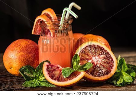 Jars Of Fresh Pulpy Blood Orange Juice On Wooden Rustic Background. Selective Focus. Summer Refreshm