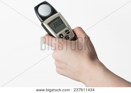 Hand Holding Light Exposure Meter, A Photograph Device For Measuring Illumination On White Backgroun