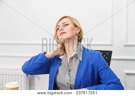 Tired Blonde Businesswoman Wears Blue Jacket In White Office Room