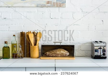 Bread In Breadbasket And Toaster On Kitchen Counter