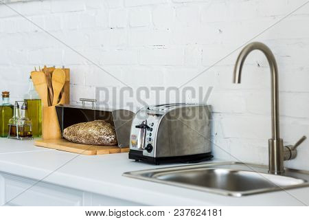 Toaster, Breadbasket With Bread Near Sink In Kitchen