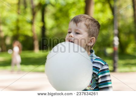 Adorable Little Boy Eating White Sweet Cotton Candy.