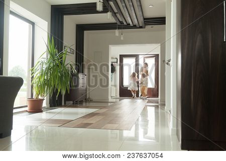 Happy Father And Kids Opening Door Entering Big Modern House Coming Back Home Holding Paper Bag With
