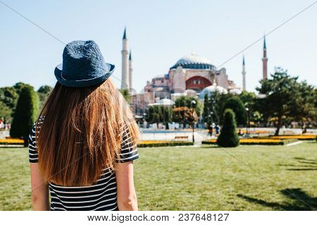 A Young Girl Traveler In A Hat From The Back In Sultanahmet Square Next To The Famous Aya Sofia Mosq