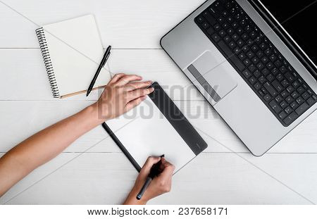 Top View Of Woman Hands With Graphic Tablet Drawing And Retouching Image On Laptop Computer, Using D