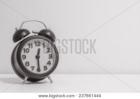Closeup Alarm Clock Show A Half Past Twelve O'clock On Wood Desk And Wallpaper Textured Background I