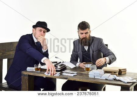 Illegal Business Concept. Company Engaged In Illegal Business. Men Sitting At Table With Piles Of Mo