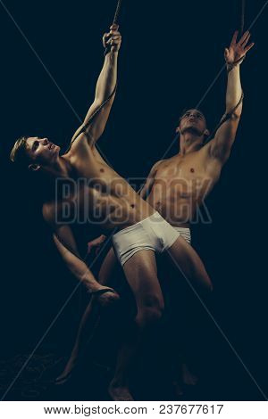 Friendship Of Men Do Gymnastic. Twins Men With Muscular Body On Rope. Circus Gymnasts At Pilates Or 