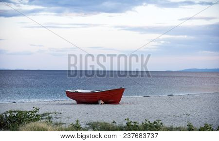 Fishermens Boat At Seacoast, On Sand On Cloudy Day With Sea On Background. Fishing Boat On Beach In 