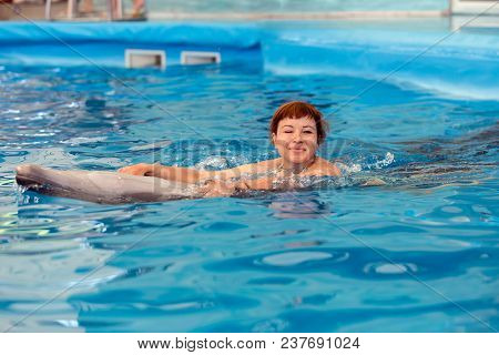 Young Happy Girl Playing With Dolphin