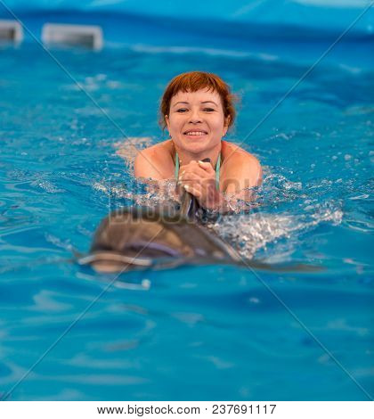 Young Happy Girl Swimming With Dolphin