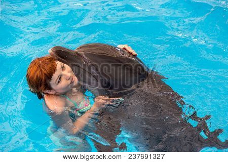 Young Happy Girl Hugs With Dolphin