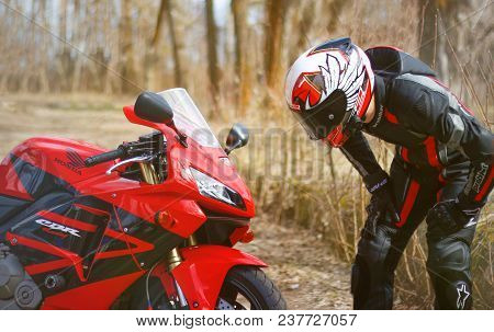 Krasnoyarsk, Russia - April 21, 2018: Beautiful Motorcyclist In Full Gear And Helmet On A Red And Bl