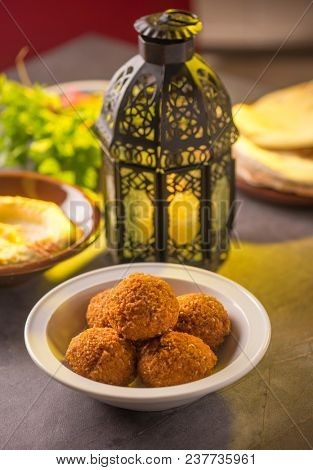 Bowl of falafel, hummus and salad arranged along with Ramadan traditional lamp.