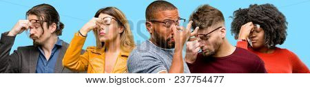 Group of mixed people, women and men with sleepy expression, being overworked and tired, rubbes nose because of weariness